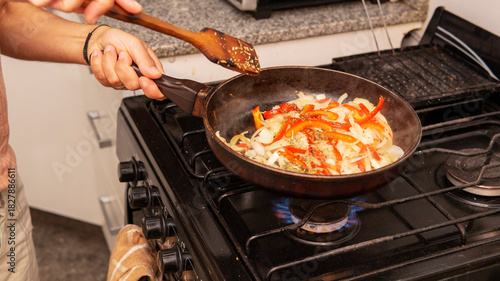 sauteing onion and bell peppers in a frying pan