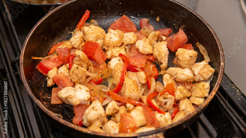 chicken, onion and bell peppers  sauteed in a frying pan