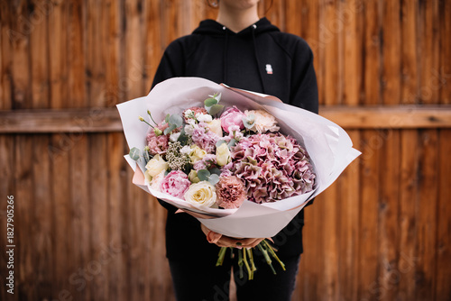 Wallpaper Mural Very nice young woman holding big and beautiful bouquet of fresh hydrangea, roses, carnations, eustoma, eucalyptus flowers in pastel pink and yellow colors Torontodigital.ca