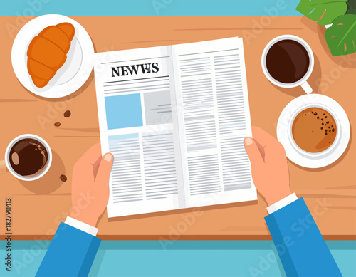 Top-down view of hands holding a newspaper, with coffee cups and a croissant on a wooden table, suggesting a relaxing morning read.