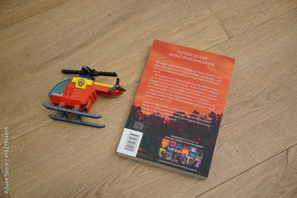 Naklejka premium Toy helicopter and book on a wooden surface