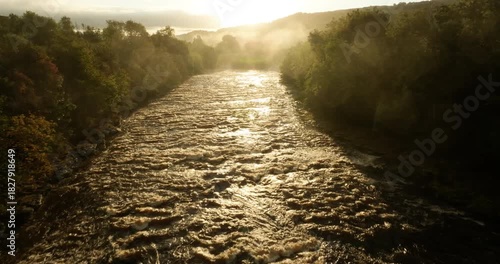 Sunrise over a river and misty forest