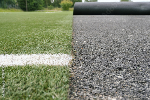 Konzept Sanierung Kunstrasen: Blick auf einen Fußballplatz mit Kunstrasen dessen Untergrund und Spielbelag gerade ausgewechselt wird, viel Copy Space