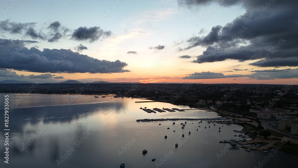 Fototapeta premium Insanely beautiful drone photography of a scenic sunrise, early in the morning, by the salt marshes in Marsala, Sicily, during a lovely morning. 
