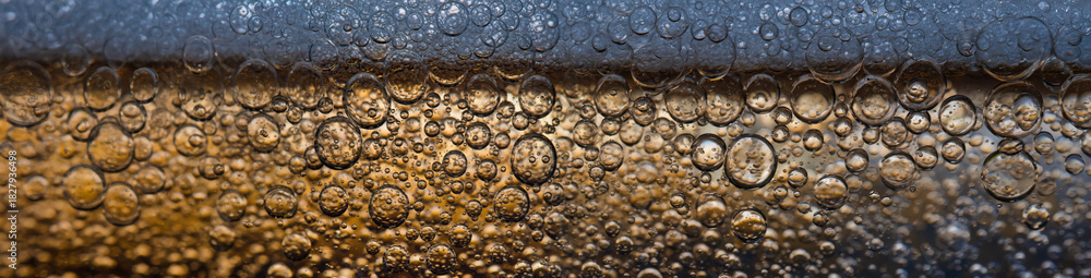Obraz premium 4K Ultrawide Close-up of fizzy drink on glass party background - Bubbles abstract golden drink close-up
