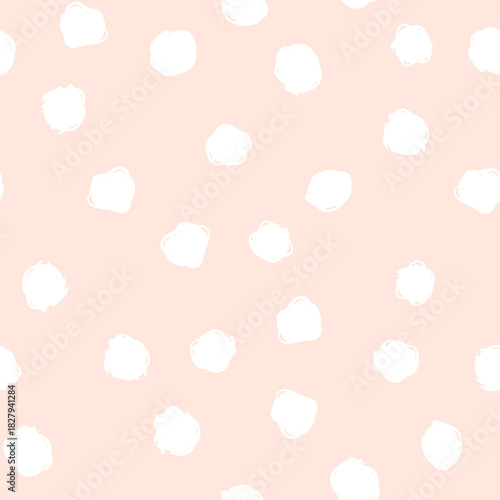 Soft pastel pink background scattered with irregular white hand drawn blot shapes. Festive dotted textured seamless pattern for textiles, stationery, wallpapers, crafts, decor, fabric, cover design.
