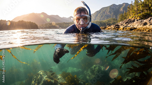 A captivating underwater scene featuring a snorkeler gliding through a lush kelp forest, highlighting the diverse marine life beneath the surface and the serene underwater atmosphere.