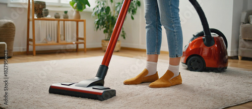 Home Cleaning: A woman tidies her home, using vacuum cleaner to suck dust and debris and maintains a clean interior, ensuring a tidy and well-kept living space.