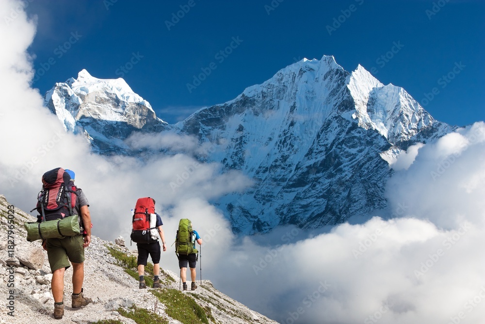 Obraz premium Mount Kangtega and Thamserku peak with three hikers