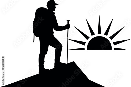 Silhouette of a hiker standing on a mountain peak at sunrise