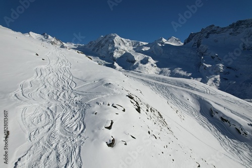Aerial drone view of snowy alpine terrain near Zermatt, Switzerland, showcasing untouched slopes, ridges, and winter mountain scenery.