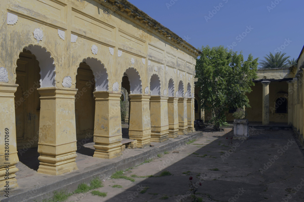 Obraz premium long, weathered side verandah of 'nasipur palace' with ornate yellow columns and cusped arches