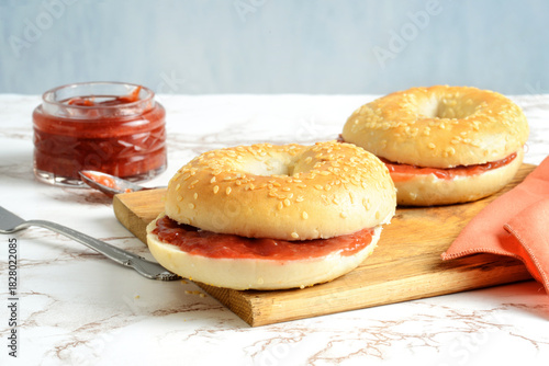 closeup of sesame seed bagel with strawberry rhubarb jam
