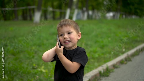 Three year old child walking in park talking on phone closeup. 4k