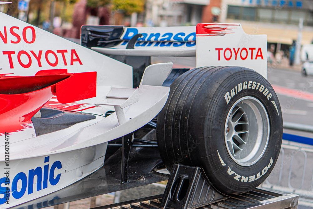 Obraz premium Toyota F1 TF-108 car on display at a public event, white livery with red and black accents, aerodynamic design, branding, Bridgestone, Panasonic, tires not touching - Kyiv, Ukraine 10-10-2024