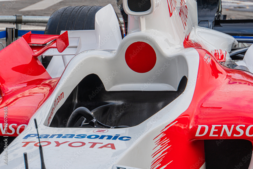 Fototapeta premium Toyota TF-108 Formula 1 car, white with red and black detailing, side profile view, sponsor logos, slick tires, rear wing, aerodynamic design, steering wheel, contro - Kyiv, Ukraine 10-10-2024