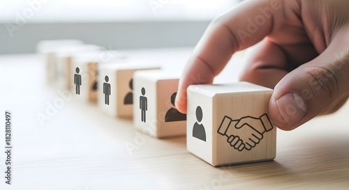 Hand placing wooden block with handshake icon in row