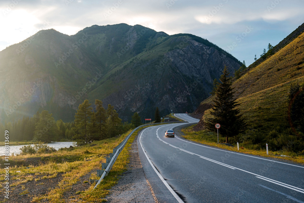Fototapeta premium a car is driving along the Chui Highway in the Altai Mountains during sunset
