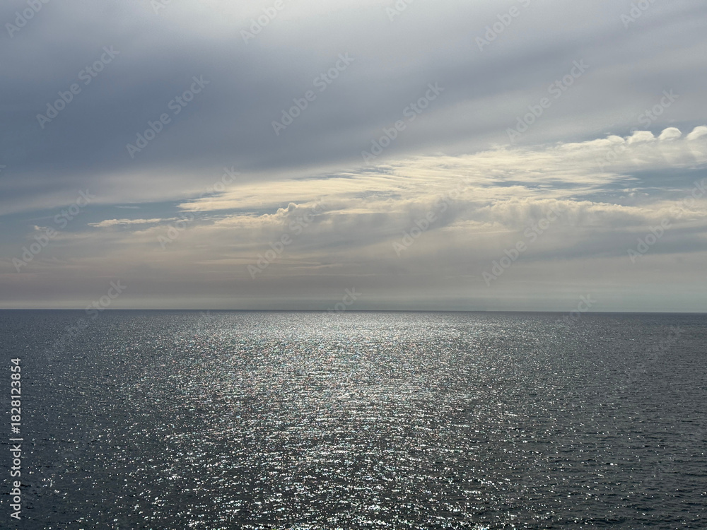 Fototapeta premium Glittering ocean and cloudy sky.