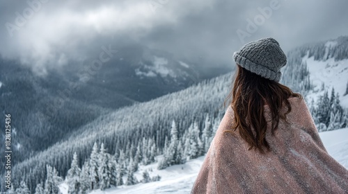 Cute Girl in Winter Standing on a Snowy Mountain Peak with Scenic Frozen Landscape