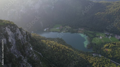 4K Aerial Drone video of Alpine lake Thumsee with turquoise water and lush green woods surrounded by tall mountains at sunset golden hour in Bad Reichenhall Germany