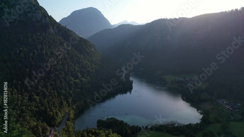 4K Aerial Drone video of Alpine lake Thumsee with turquoise water and lush green woods surrounded by tall mountains at sunset golden hour in Bad Reichenhall Germany
