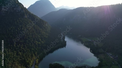 4K Aerial Drone video of Alpine lake Thumsee with turquoise water and lush green woods surrounded by tall mountains at sunset golden hour in Bad Reichenhall Germany