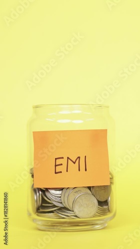 Vertical Video of Saving money for EMI. Putting Indian Rupee coins in Glass Jar