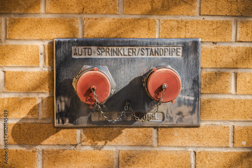 Fotografie Fire department connection with dual standpipe and auto-sprinkler caps mounted o