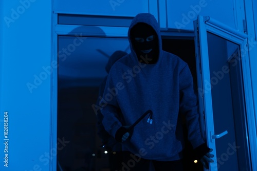 Photos Thief breaking into office through window at night