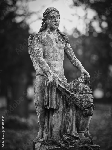 Photography Weathered stone angel holding an urn at Goat Gate Cemetery in Bratislava, photographed in black and white