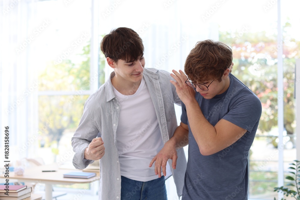 Obraz premium Teenage boy bullying his classmate in classroom