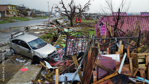 Devastating aftermath of a natural disaster showing a destroyed car and debris scattered across a street
