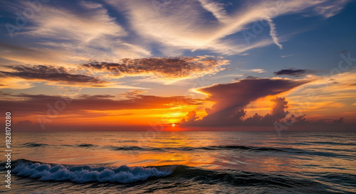 Fototapeta Naklejka Na Ścianę i Meble -  Vibrant Ocean Sunset with Dramatic Clouds and Golden Reflections