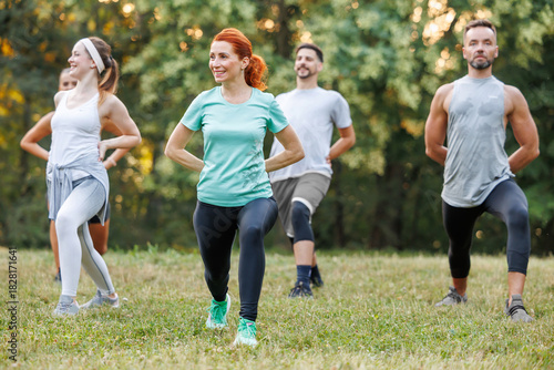 Cuadro en lienzo Group exercise session in a park during a sunny day with enthusiastic participan