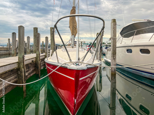 Fotografie Beautiful Red Sailboat Docked in the Harbor on Lake Michigan