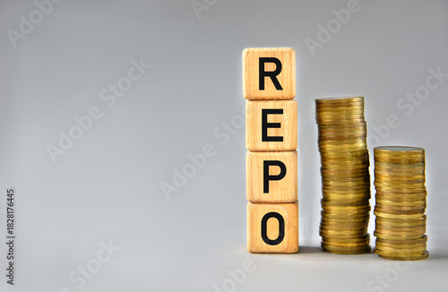 REPO - word on wooden cubes on the background of stacks of coins