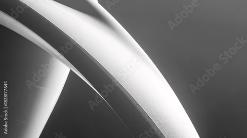 Close up of curved white tubes against a dark gray background.