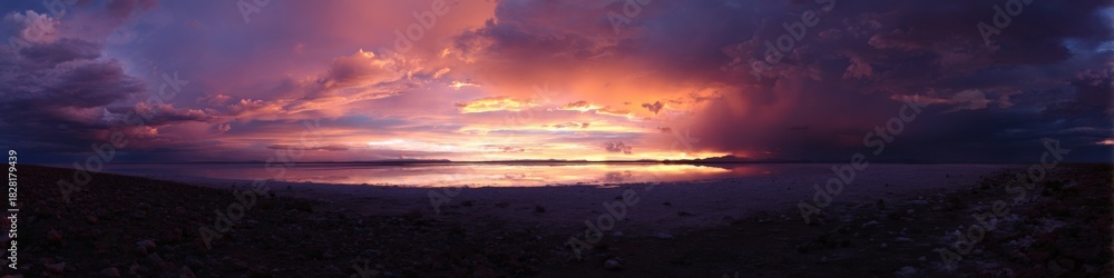 Fototapeta premium Majestic sunset over salt flats with dramatic clouds and vibrant colors