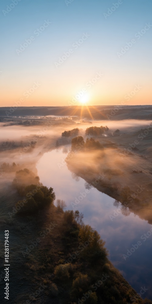 Obraz premium Sunrise over serene river with misty landscape and trees in early morning light