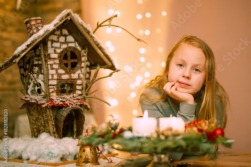 Ein Mädchen am Abend neben den Adventskerzen