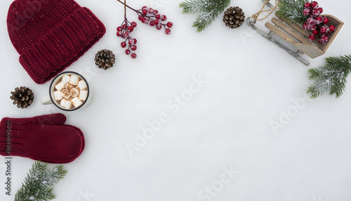 Winter wonderland flat lay with warm accessories, hot cocoa, and festive decorations on fresh white snow, perfect for cozy holiday themes and seasonal greetings.