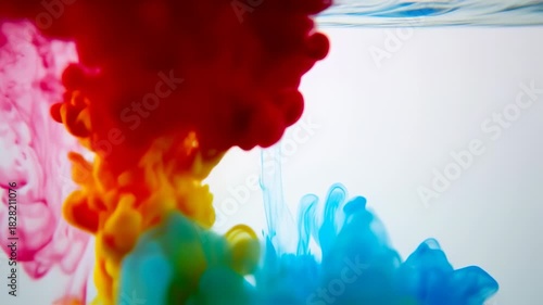 Colorful ink drops dispersing in clear water, creating vibrant abstract patterns
