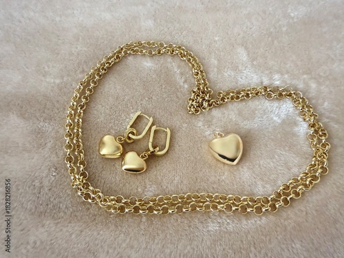 A gold-plated silver jewelry set featuring a delicate chain with a heart pendant and matching heart drop earrings. Elegant accessories for fashion, gifts, and romantic themes