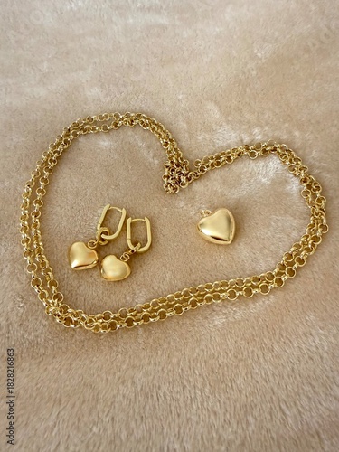 A gold-plated silver jewelry set featuring a delicate chain with a heart pendant and matching heart drop earrings. Elegant accessories for fashion, gifts, and romantic themes