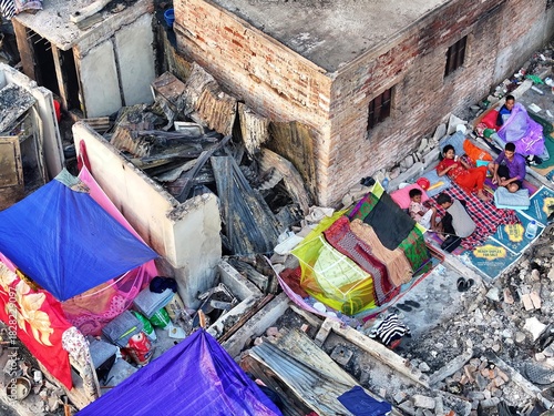Dhaka, Bangladesh - 28 November 2025: Aerial view of the Korail slum, a landscape of makeshift shelters where life unfolds on rooftops under a relentless sun.