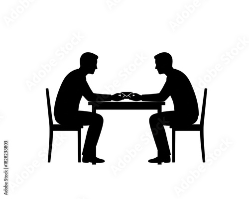 Two people sitting at a table playing cards