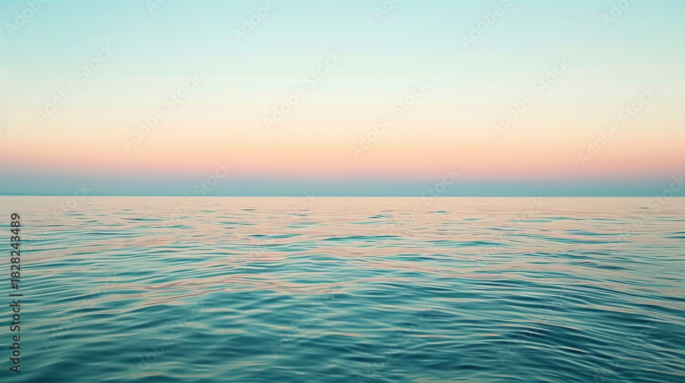 Fototapeta premium Calm ocean water reflecting the pastel colors of the sunset sky at dusk
