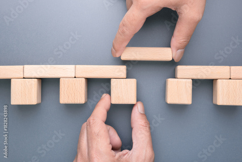 Teamwork hands building a wooden bridge to fill the gap