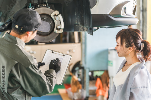 Картината върху платно A female customer and a male mechanic receive an explanation about a car that ha